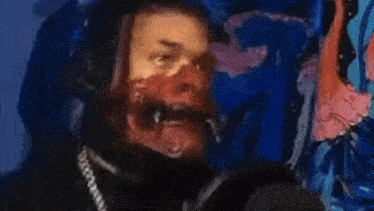 a man is wearing a mask and headphones in front of a blue wall .