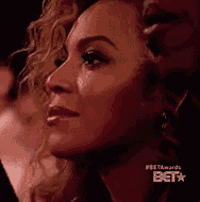 a close up of a woman 's face with a bet logo in the background