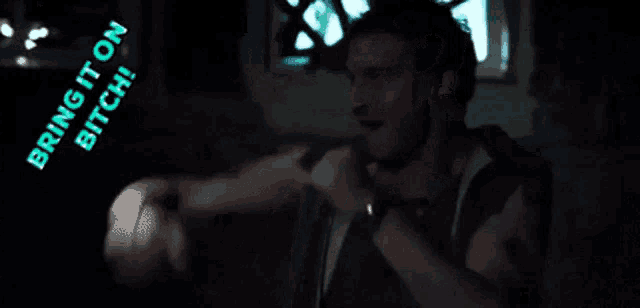 a man in a dark room with the words bring it on bitch behind him
