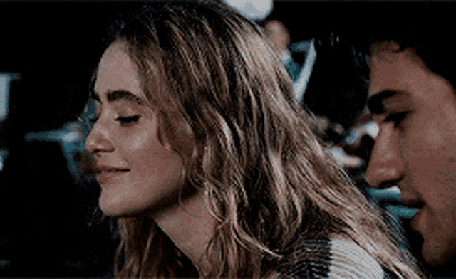 a man and a woman are looking at each other and the woman is smiling