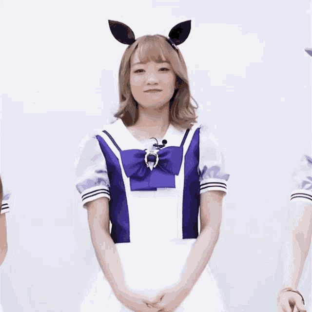 a girl wearing a purple and white outfit with a bow and ears