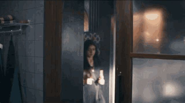 a woman in a black shirt is standing in a doorway