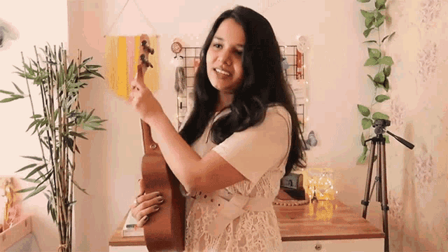 a woman in a white dress is holding a guitar in her hands
