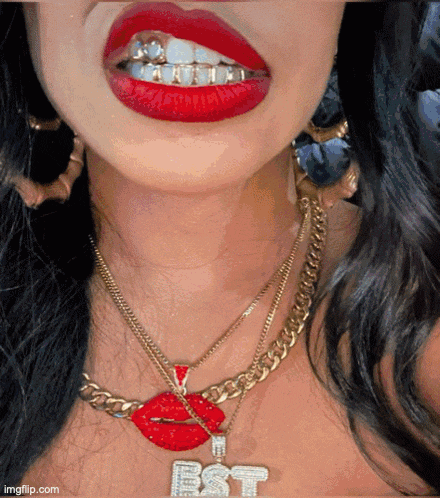 a close up of a woman 's mouth with red lipstick and a necklace with the letter bst on it
