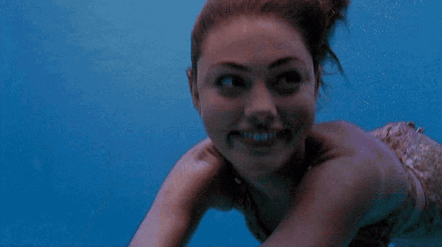 a naked woman is smiling in the water