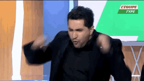 a man is dancing in front of a screen that says l' equipe