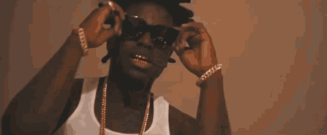 a man wearing a white tank top and a gold chain