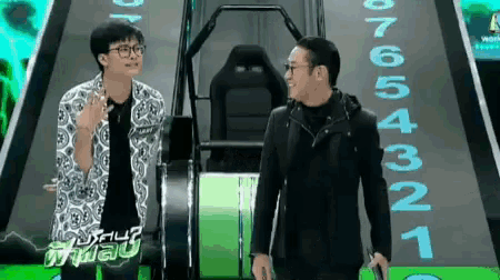 two men are standing in front of a staircase with the number 123456781 on it