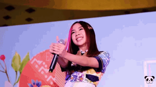 a woman holding a microphone in front of a sign that says hmr