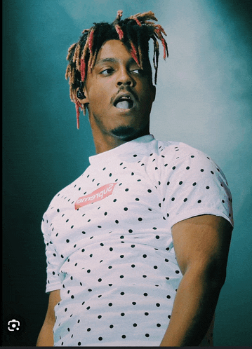 a man wearing a polka dot shirt with supreme on it