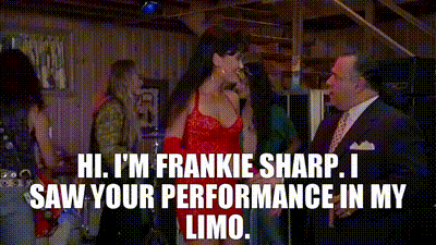 a woman in a red dress is talking to a man in a suit and tie .