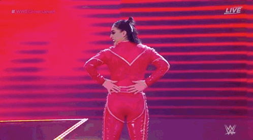 a woman is standing on a stage with her hands on her hips .
