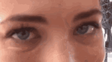 a close up of a person 's blue eyes with a serious look on their face .