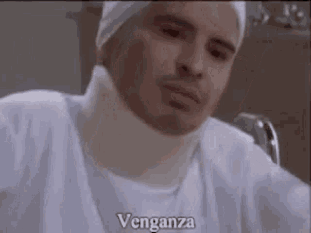 a man with a broken neck and a bandage on his neck is sitting in a hospital bed .