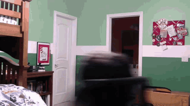 a bedroom with green walls and a bulletin board with stickers on it