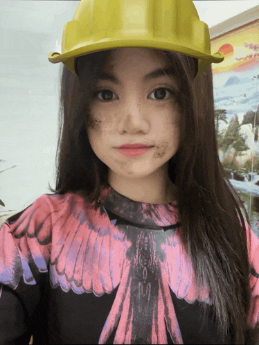 a young girl wearing a yellow hard hat