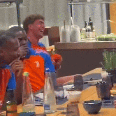 a group of people sitting at a table with bottles of water and bowls