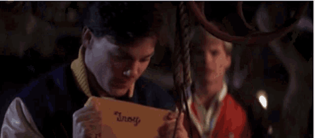 a man is screaming with his mouth open and the words `` you goonie '' written on his face .