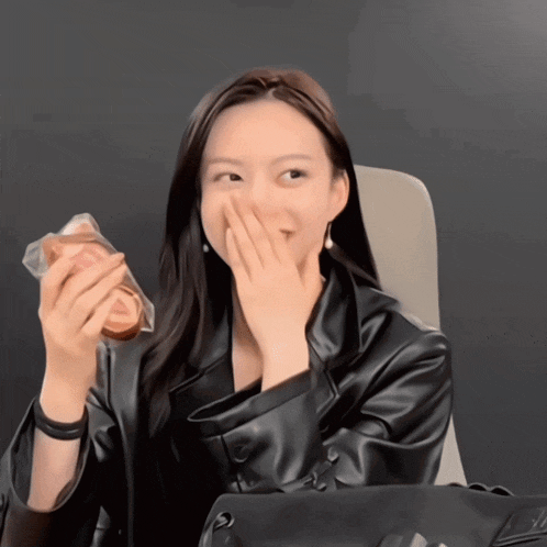 a woman covering her mouth with her hand while holding a bag of bread