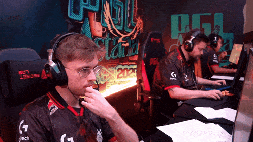 a man wearing headphones sits at a desk in front of a sign that says " secret lab "