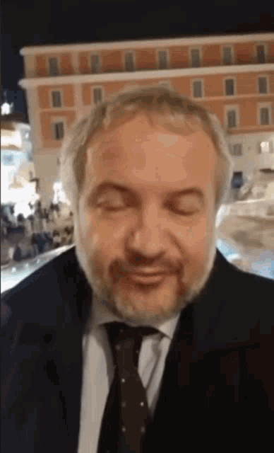 a man with a beard wearing a suit and tie