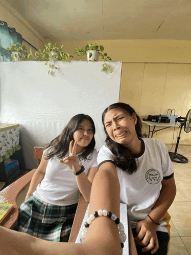 two girls pose for a picture with one wearing a shirt that says ' philippines '