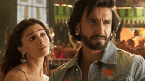 a man with a beard and a woman with a bindi on her forehead are standing next to each other