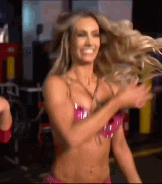 a woman in a pink bikini is dancing in a room .