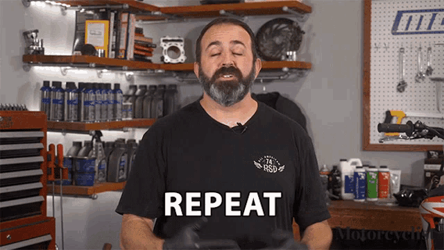 a man wearing a black shirt that says repeat