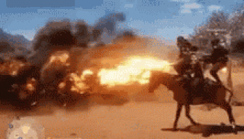 a man is riding a horse in a video game while a fireball is exploding in the background .