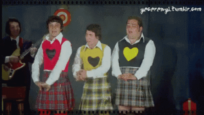 a group of men wearing kilts and sweaters with hearts on them are standing next to each other