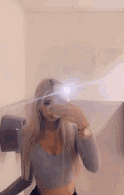 a woman is taking a selfie in front of a mirror .