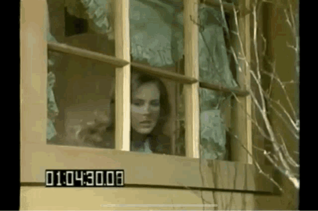 a woman is looking out of a broken window with a timer that says 1:04:30