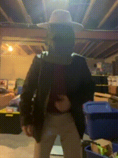 a person wearing a cowboy hat is standing in a dark room