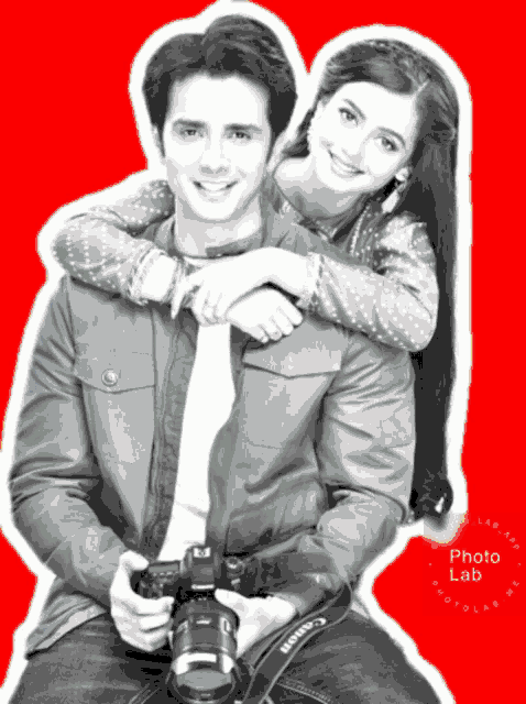 a man is holding a canon camera and a woman is behind him
