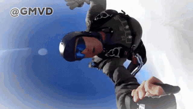 a man wearing a helmet and goggles is flying through the air with the words @gmvd behind him