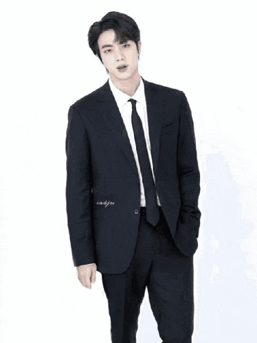 a man in a suit is standing in a kitchen