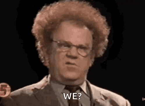 a man with curly hair and glasses is wearing a suit and tie and saying `` we '' .