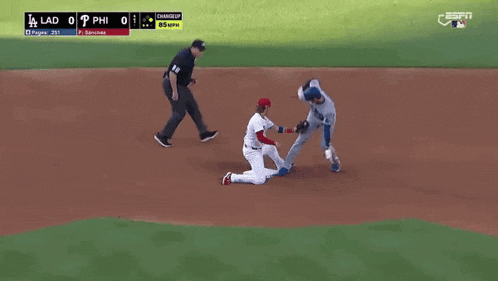 a baseball game is being played on a field and a player is kneeling on the ground .