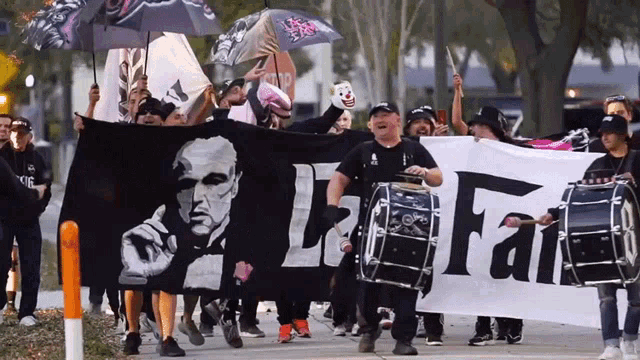 a group of people are marching down a street holding a banner that says ' liberty and fair '