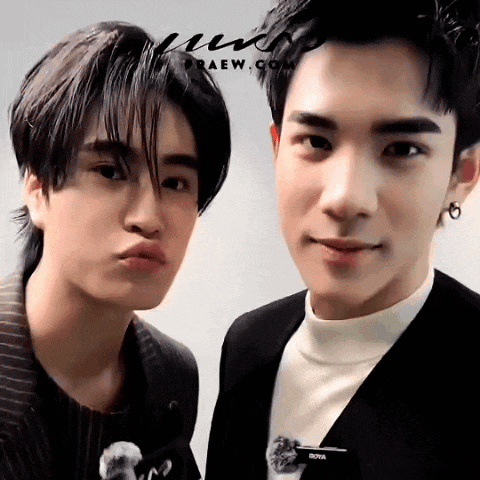 two young men are posing for a picture and one has a brooch with the word nova on it