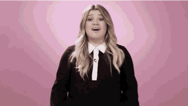 a woman in a black shirt with a white collar and tie