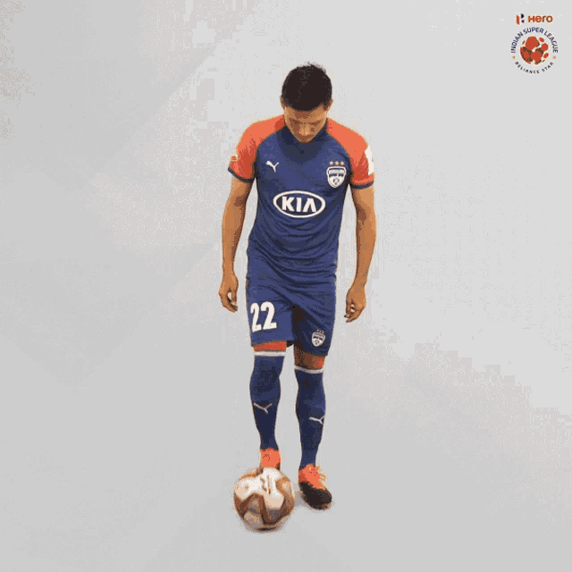 a soccer player wearing a kia jersey kicks a ball