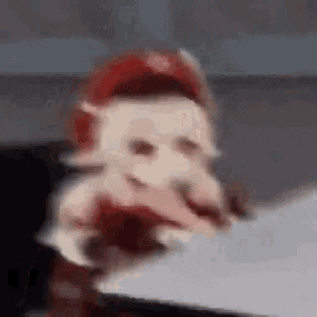 a doll is sitting at a table in a blurry photo .