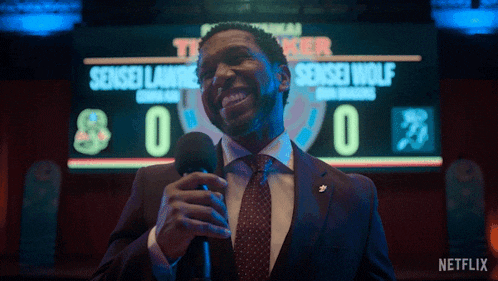 a man stands in front of a scoreboard that says sensei wolf