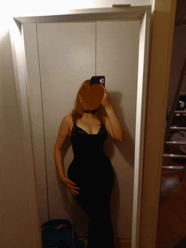 a woman taking a picture of herself in a mirror with a heart shaped object in front of her face