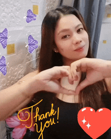 a woman making a heart shape with her hands with the words thank you written on her top