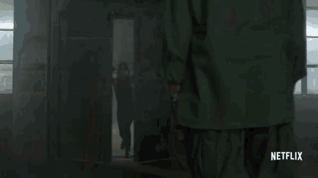 a woman is standing in a dark room with a netflix logo on the bottom
