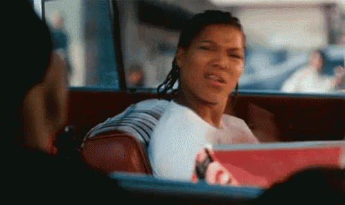 a woman is sitting in the back seat of a car holding a coca cola box .