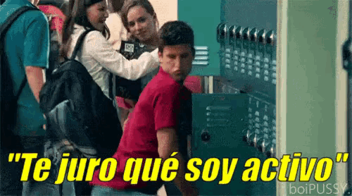 a man in a red shirt is standing in front of a locker with the words te juro que soy activo above him